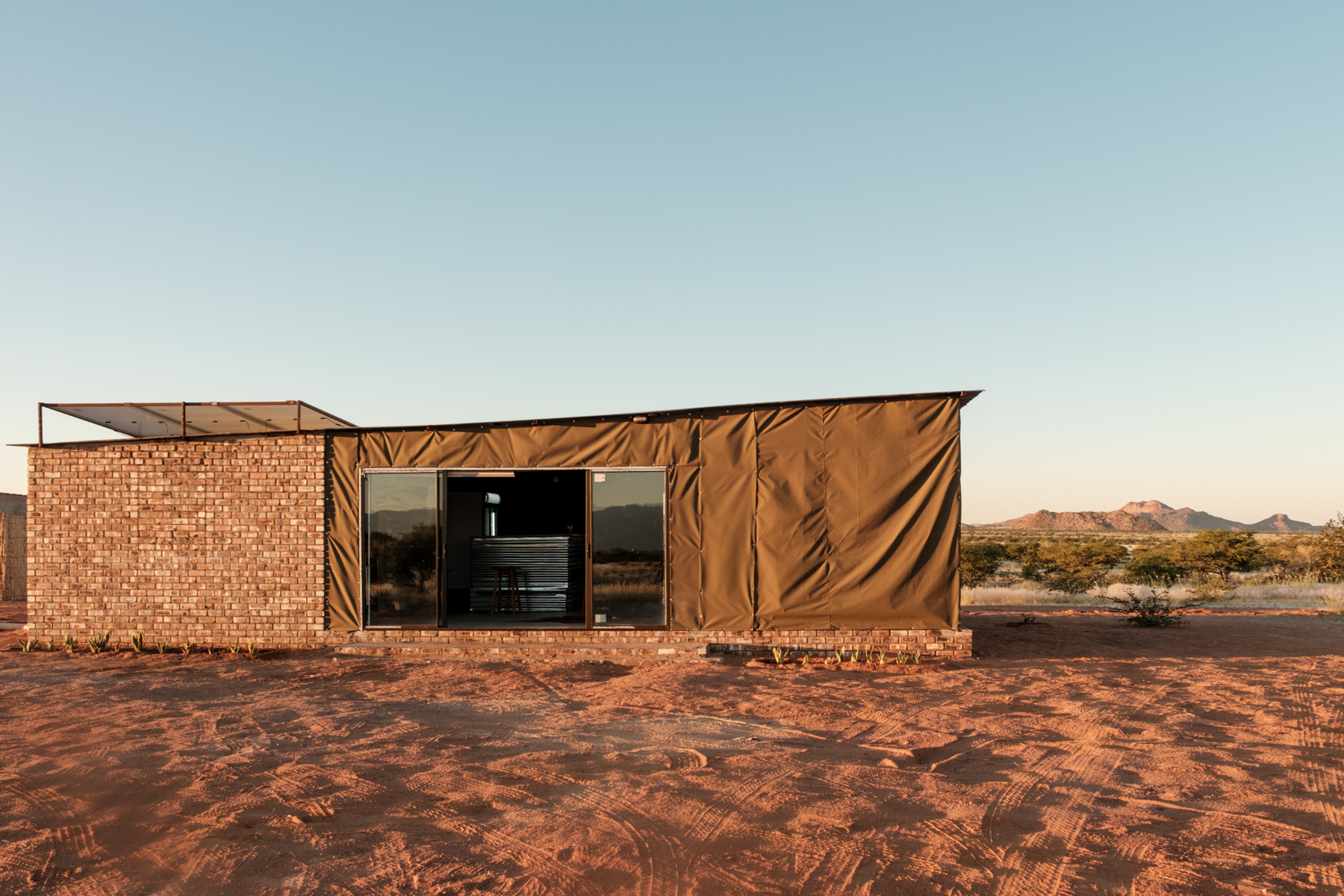 Exterior view of Elephant Rest Tented Camp accommodation with Brandberg Mountain at dusk